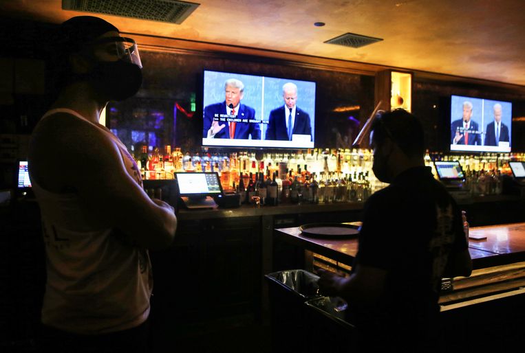 Werknemers in een bar in Hollywood in Los Angeles kijken haar het debat. Beeld Getty Images