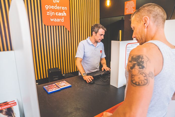 Steeds meer Belgen wenden zich tot aankoophuizen waar je snel spullen kan wisselen naar cashgeld.
Een man ruilt een paar games in bij Cash Converters in Gent.