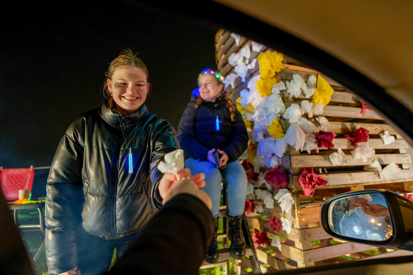 Iedere deelnemer vouwt een roosje van een servet. En zo groeit de boog in de lichtjesroute gestaag.