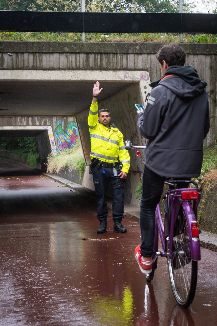 Breda - Pix4Profs/René Schotanus. Politieman houdt appende jongen op de fiets aan.