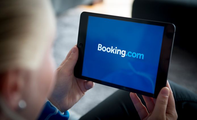 Een vrouw bekijkt de website van Booking.com op een tablet.