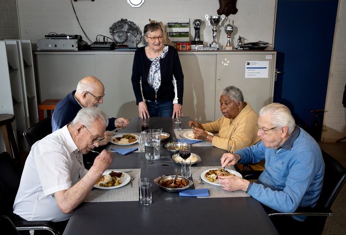 Gasten (vanaf links) Cor van de Schoot, Harry Sanders, Edith Termeer en Toon Hageman genieten van een maaltijd in het eetpunt in Boskant. In het midden staat vrijwilliger Ans van Hastenberg.