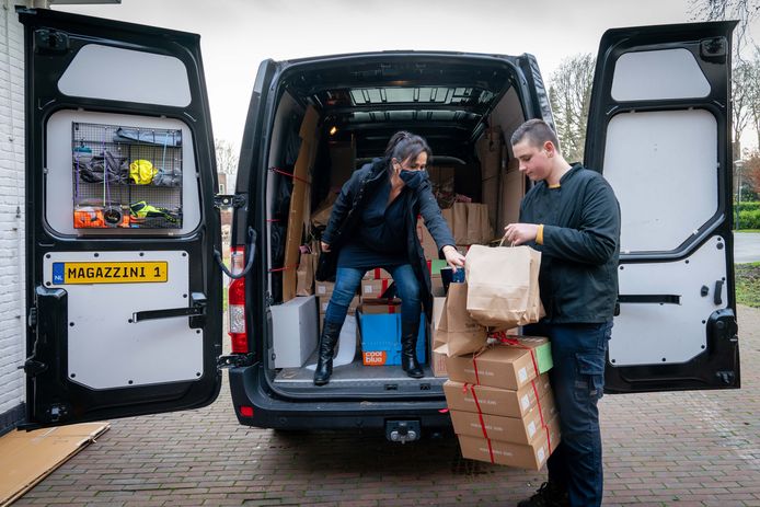 Niels den Hartog neemt de kerstpakketten in ontvangst uit handen van Anne Mieke Verhoeven.