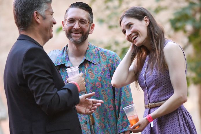 Amanda Knox geniet samen met haar verloofde Christopher Robinson (midden) van een cocktail op het Criminal Justice Festival in Italië, terwijl ze met een gast praat.