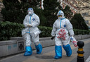 Chinese medewerkers in de strijd tegen de pandemie dragen pakken op verspreiding van het virus tegen te gaan in Peking, 2 december 2022. Terwijl China de lockdownmaatregelen versoepelt, versterkt het de greep op demonstranten.