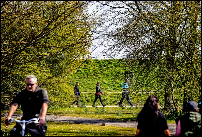 Mensen wandelen op anderhalve meter afstand van elkaar door het Haarlemmermeerse Bos . De fietsers genieten ook van het groen en het mooie weer.