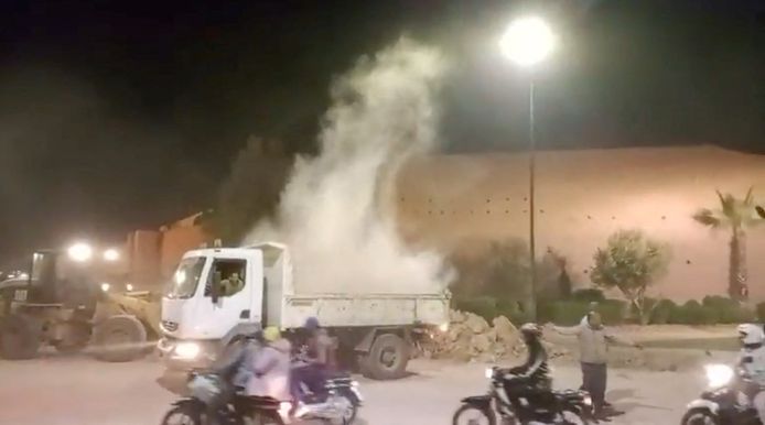 Een vrachtwagen probeert puin te rapen om zoveel mogelijk overlevende vanonder het puin te halen.