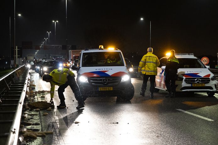 De politie ruimt de kratten met brood op die op de A20 vielen.