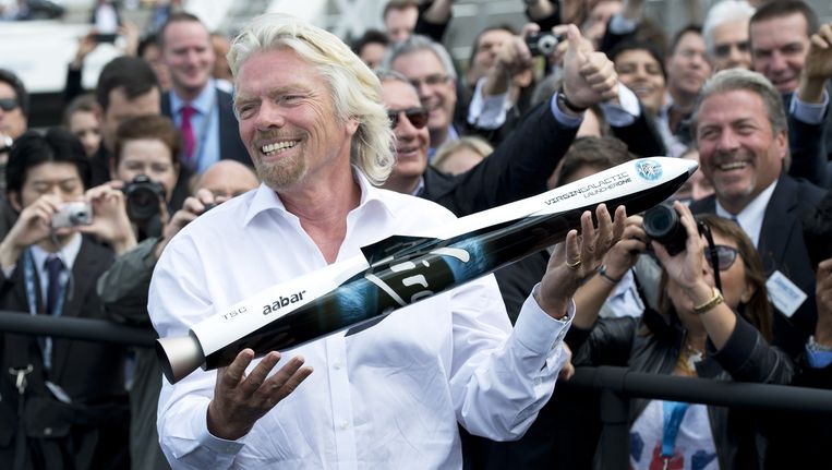 Richard Branson houdt een model vast van Launcher One voor Virgin Galactic. Beeld AFP