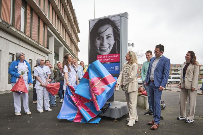Obstetrieverpleegkundige Milou onthult een billboard, samen met Carina Hilders en Arjen Hakbijl van de Raad van Bestuur van Reinier de Graaf.