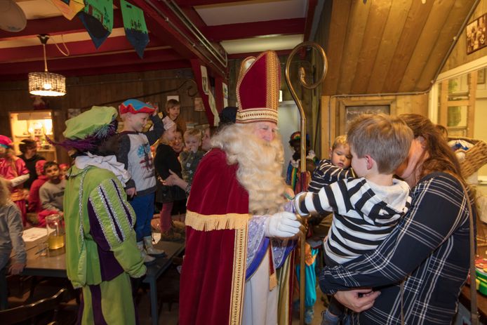 Sinterklaas geeft een kleine bezoeker een hand in het Sinterklaashof in Nuenen.