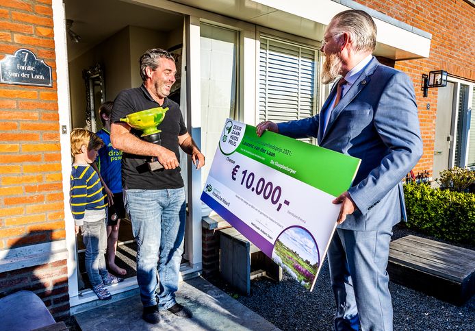 Huibert Steen geeft de symbolische cheque aan Mijnsheerenlander Laurens van der Laan, de winnaar van de eerste Duurzaamheidsprijs in de gemeente Hoeksche Waard in 2021.