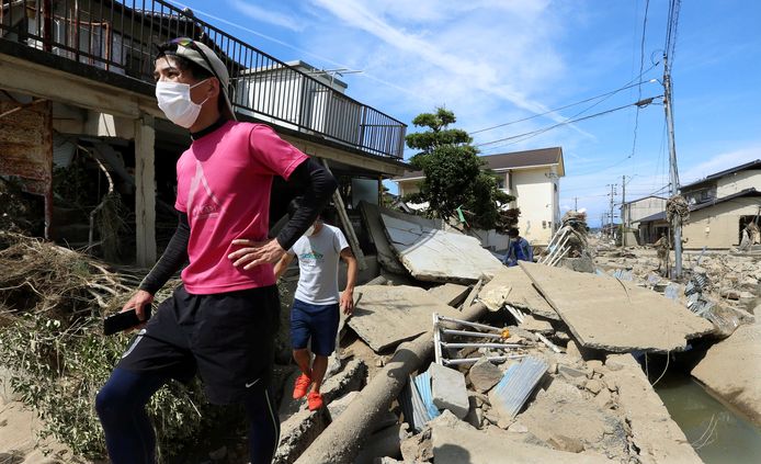 Mensen lopen door de ravage in een wijk in Kurashiki, in de prefectuur Okayama.
