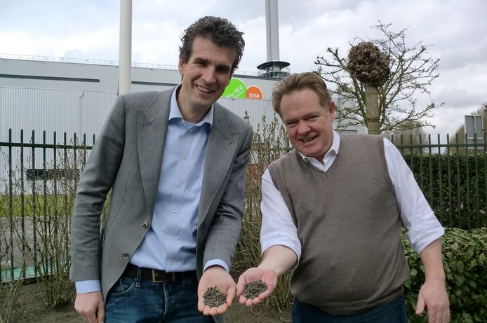 Archieffoto met links Lodewijk Burghout van Biomineralen BV en naast hem directeur Marc Das van de Roosendaalse afvalverwerker Suez ReEnergy. In hun handen droge mestkorrels.