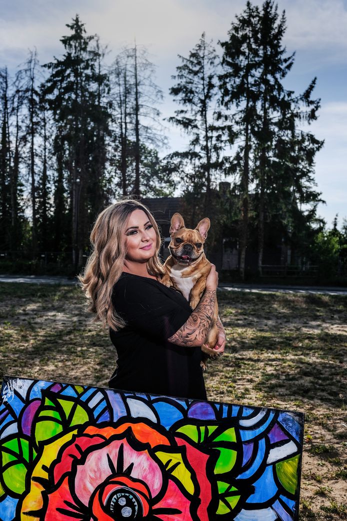Sharon Elfring met een eigen schilderij en hond Budda.