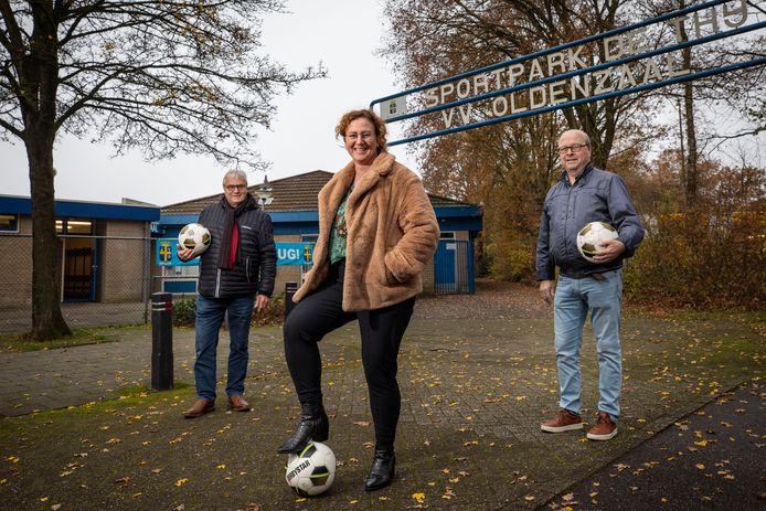 Het dagelijks bestuur van VV Oldenzaal bij de ingang van sportpark De Thij. In het midden secretaris Sandra Pool, geflankeerd door voorzitter Cor Oostendorp (links) en penningmeester Paul Leussink.