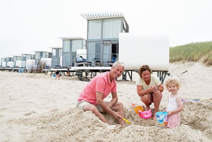 Hans van Leeuwen, zijn vrouw Emma Hendriks en kleindochter Billy (2) voor het strandhuis in Cadzand-Bad.