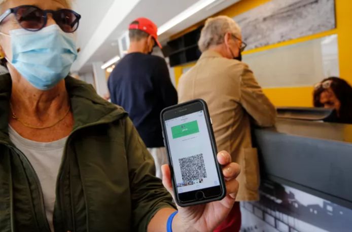 Une femme vaccinée présente son passeport vaccinal pour pouvoir entrer dans une salle de sport avec piscine, à Tel Aviv.