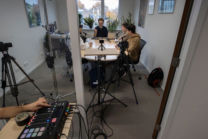 In de directeurskamer van het Nuenens College praat presentator Kai Bodewitz (midden) met leerlingen in de eerste aflevering van Hoezo Da?, de podcast voor en door leerlingen.