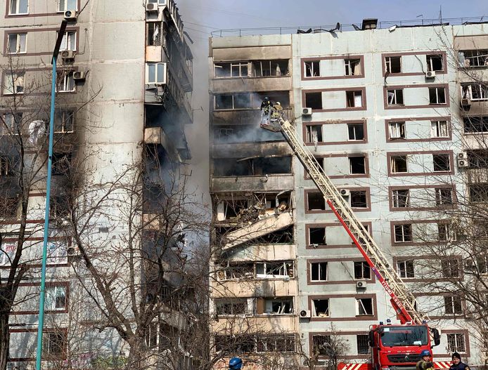 De brandweer aan het werk bij het gebombardeerde gebouw in Zaporizja.
