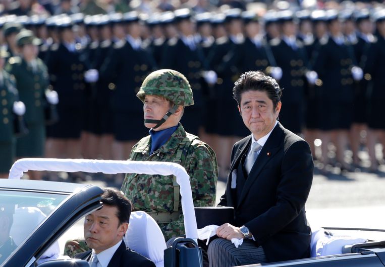 De Japanse ex-premier Shinzo Abe (rechts) in 2013 tijdens een inspectie van het Japanse leger. Beeld AP
