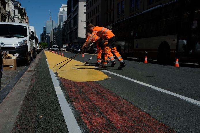 Arbeiders schilderen een fietspad op de Jacqmainlaan.