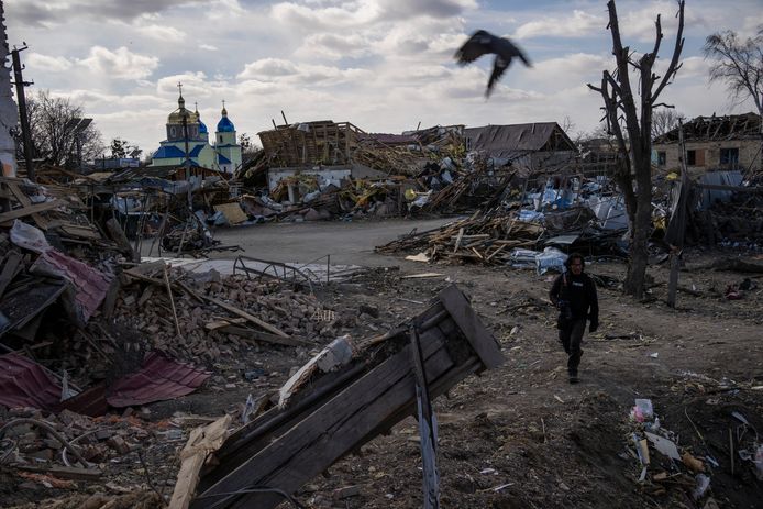 Een journalist wandelt tussen de ruïnes in Byshiv nabij Kiev na een Russische aanval. De foto is op zondag 27 maart genomen.