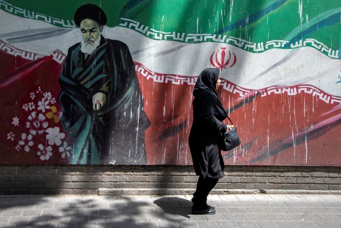 Una donna iraniana passa davanti a un murale dell'ex leader iraniano Ayatollah Ruhollah Khomeini.