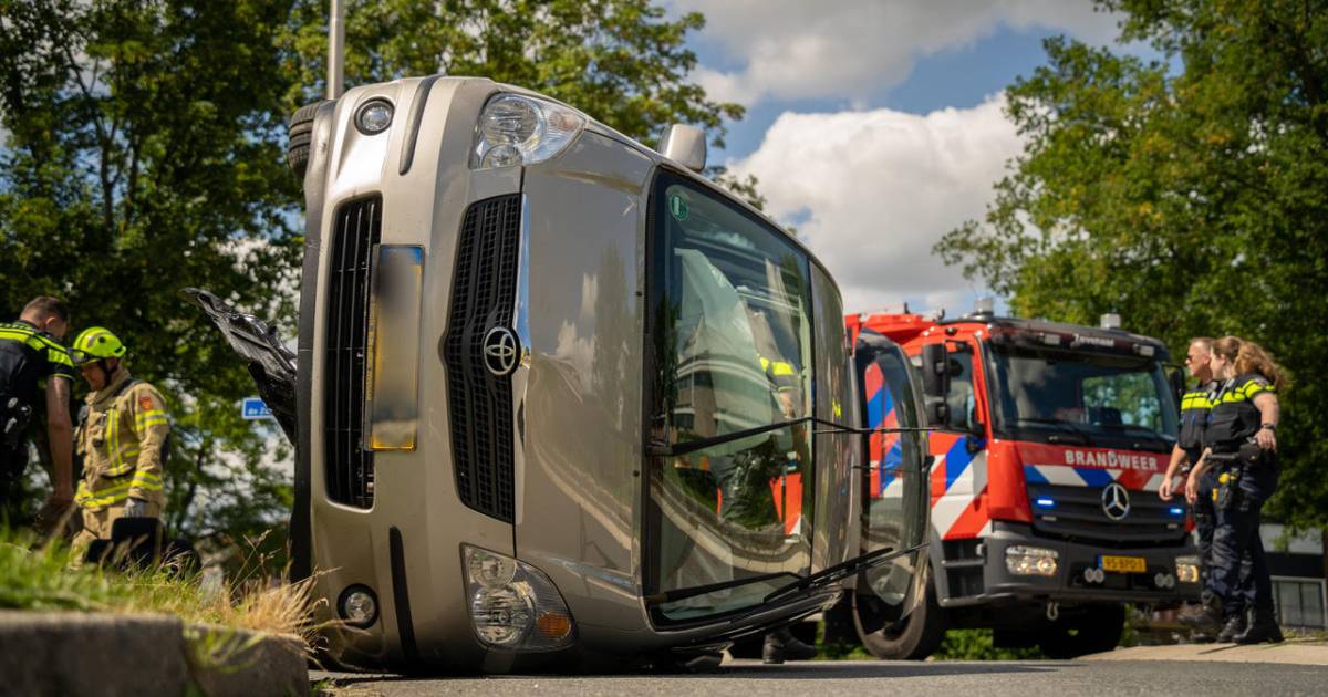 Automobilist maakt schuiver op rotonde en raakt bekneld in gekantelde auto.