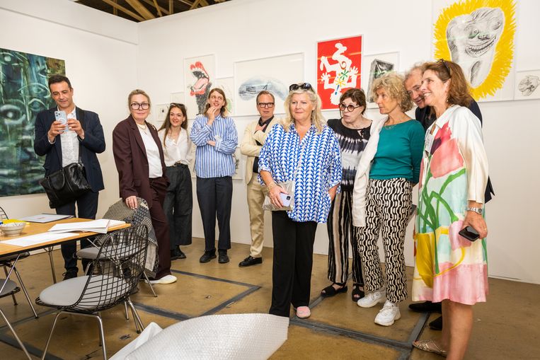 Rotterdam Art Week 2022 in de Van Nelle Fabriek in Rotterdam. Bezoekers kijken nieuwsgierig naar een schilderij dat wordt uitgepakt.  Beeld Simon Lenskens