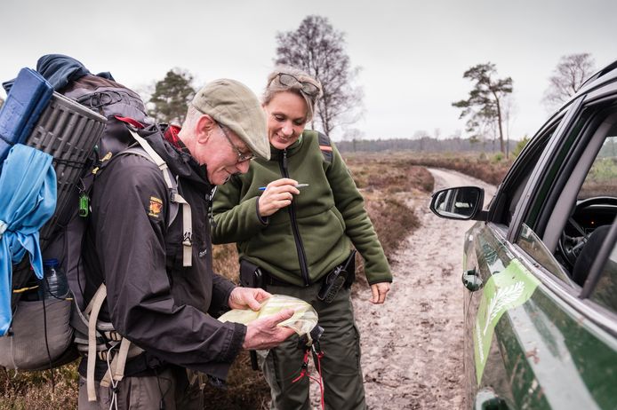 Boswachter Ine Nijveld van Staatsbosbeheer helpt ‘rugzakloper’ Aart Twigt verder met een overnachtingsplaats. Twigt is het vuurwerklawaai in de randstad ontvlucht en wandelt al een week in Oost-Nederland.