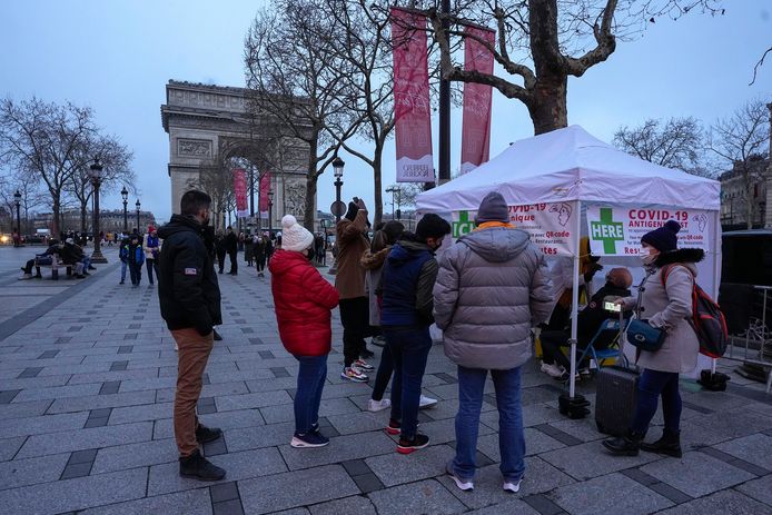 Mensen schuiven aan voor een snelle antigeentest aan de voet van de  Arc de Triomphe in Parijs.