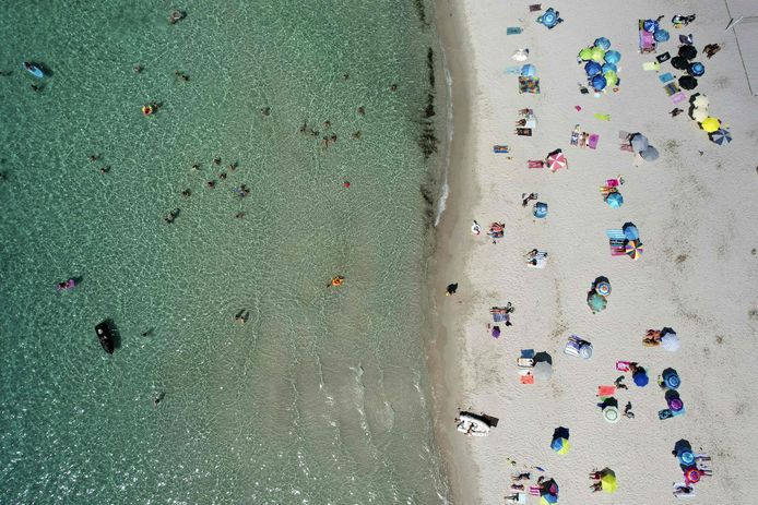 Toeristen op het Mare e Sole-strand in Pietrosella op het Franse mediterrane eiland Corsica.