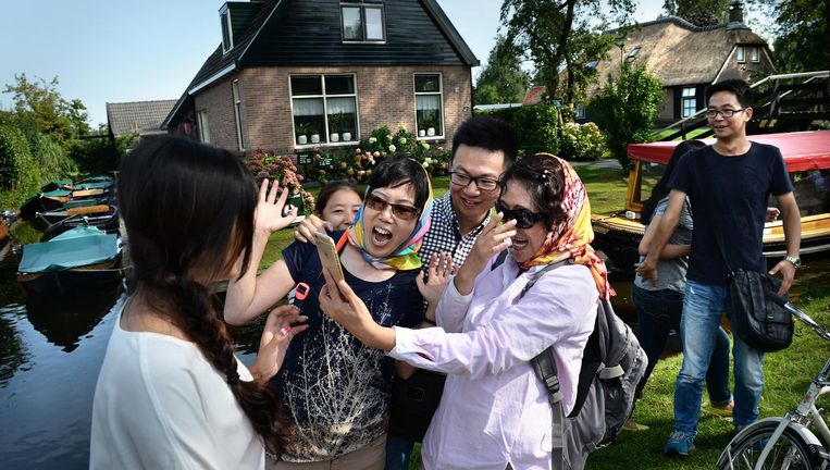Chinese toeristen hebben plezier bij een bezoekje aan Giethoorn. Beeld Marcel van den Bergh / de Volkskrant
