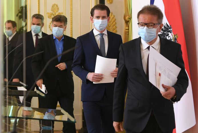 De bondskanselier en verschillende ministers, allemaal met een mondmasker, voor hun gezamenlijke persconferentie vandaag in Wenen over het versoepelen van de coronamaatregelen.