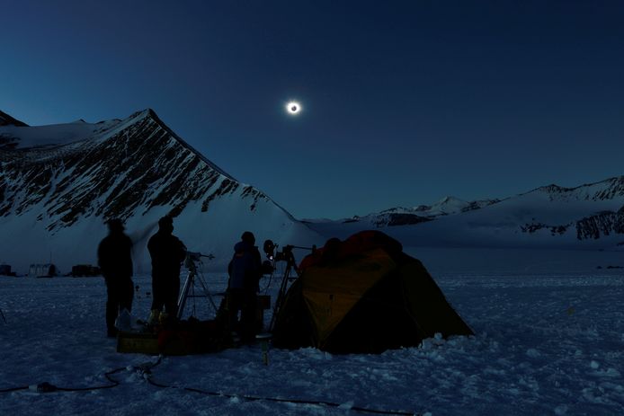 Mensen bekijken de zonsverduistering vanaf het wetenschappelijke poolstation 'Glaciar Union' in Antarctica, op Chileens grondgebied.