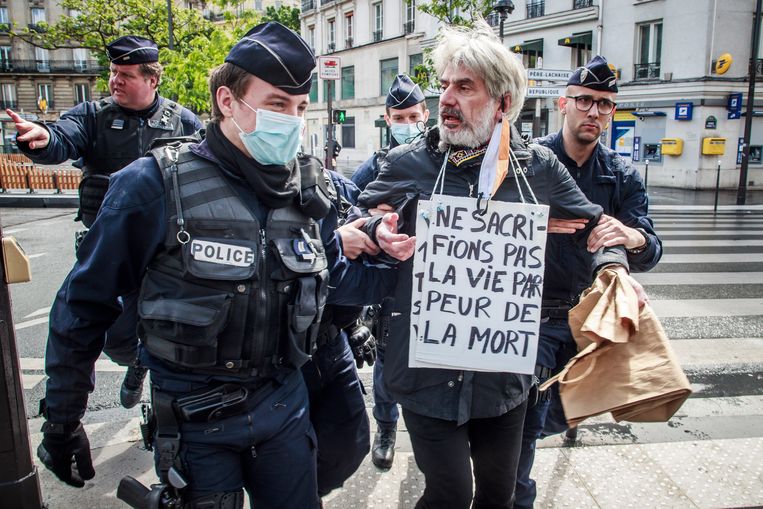 ‘Laten we het leven niet opofferen uit angst voor de dood.’ Op 1 mei trok een kleine minderheid van de Fransen de straat op om hun ongenoegen over de draconische maatregelen te uiten.  Beeld EPA