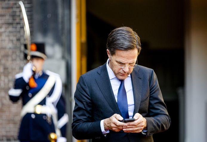 Minister-president Mark Rutte gebruikt zijn mobiele telefoon.