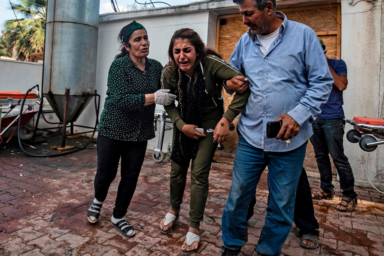 Een vrouw reageert op het lichaam van een man gedood door Turks artillerievuur, die net arriveert bij een ziekenhuis in de buurt van Tal Tamr, kort na het staakt-het-vuren. Beeld AFP