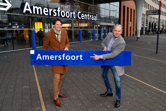 Nico Meijer (rechts) met het door hem gekochte stationsbord voor Amersfoort Centraal. Naast hem Kees Rutten van ProRail.