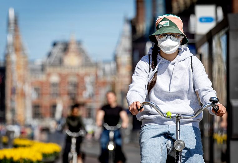 Een fietser in Amsterdam draagt een mondkapje. Beeld ANP