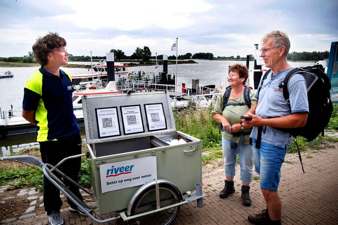 Een medewerker van Riveer geeft toeristen informatie over vervoer over water.