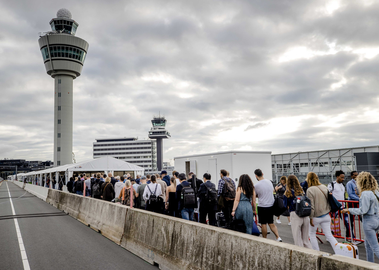 Wachtende reizigers bij vertrekhal 1/2 op luchthaven Schiphol.
