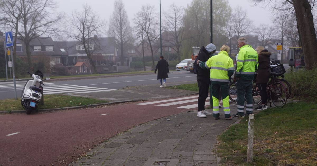 Personeel dierenambulance helpt gewonde scooterrijder na aanrijding met fietser.