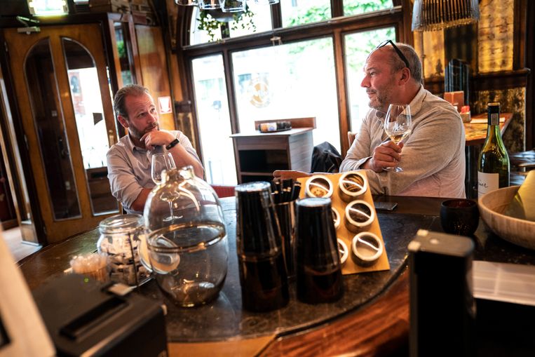 Joost van Keulen (links) is heel blij dat de café 's weer open gaan, hier in gesprek met horecabaas Patrick Beijk in Mr Mofongo in Groningen. Beeld Reyer Boxem