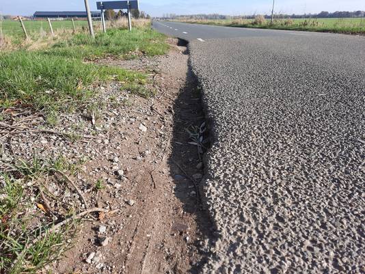 De bermen langs De Bellaard, een polderweg tussen Vlijmen en 's-Hertogenbosch. De bermen zitten vol gaten en kuilen, terwijl Den Bosch jaren geleden zijn deel van de weg al heeft verbreed en geasfalteerd.