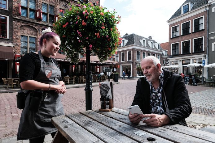 Een bezoeker van het terras van Stadsbierhuys De Waag in Doesburg bestelt via een QR-code.
