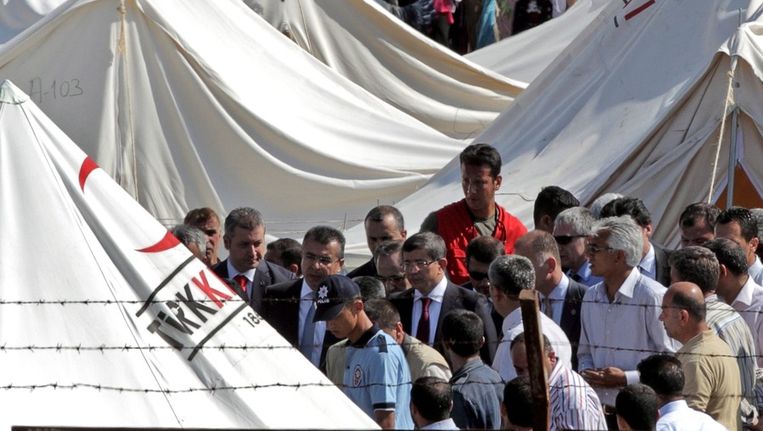 Turks minister van Buitenlandse Zaken Davutoglu wordt omringd door Syrische vluchtelingen in een kamp op de Turks-Syrische grens. © ANP Beeld 