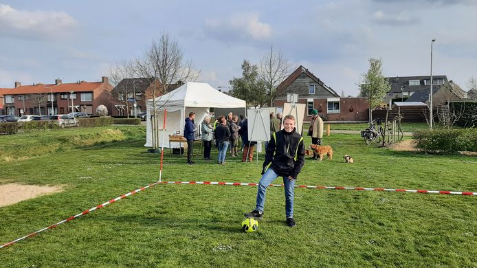 Jaimy zegt namens tientallen jongeren te spreken als hij pleit voor een kunstgrasveldje in Hooge Zwaluwe. 'Dit veld is onbespeelbaar.'  Omwonenden (op de achtergrond) zijn tegen.