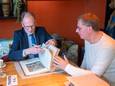 Taxateur Arie Molendijk bekijkt een van de vele oude bijbels en atlassen die in Ede ter tafel kwamen.